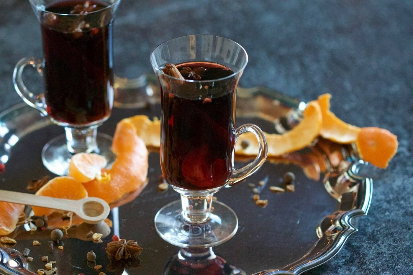Zwei Gläser Glühwein mit Orangenschalen und Gewürzen