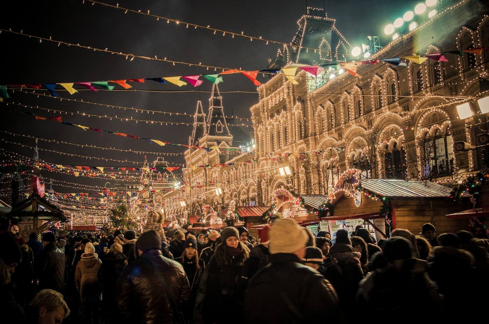 Volle Weihnachtsmarkt-Gasse unter Lichterketten