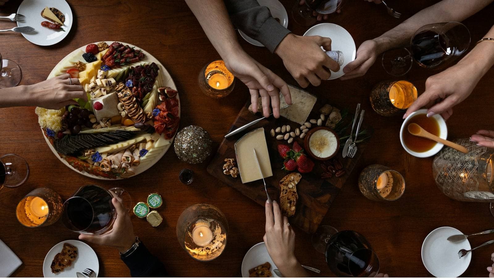 Gemeinsames Essen an einem gedeckten Tisch mit Käse und Kerzen